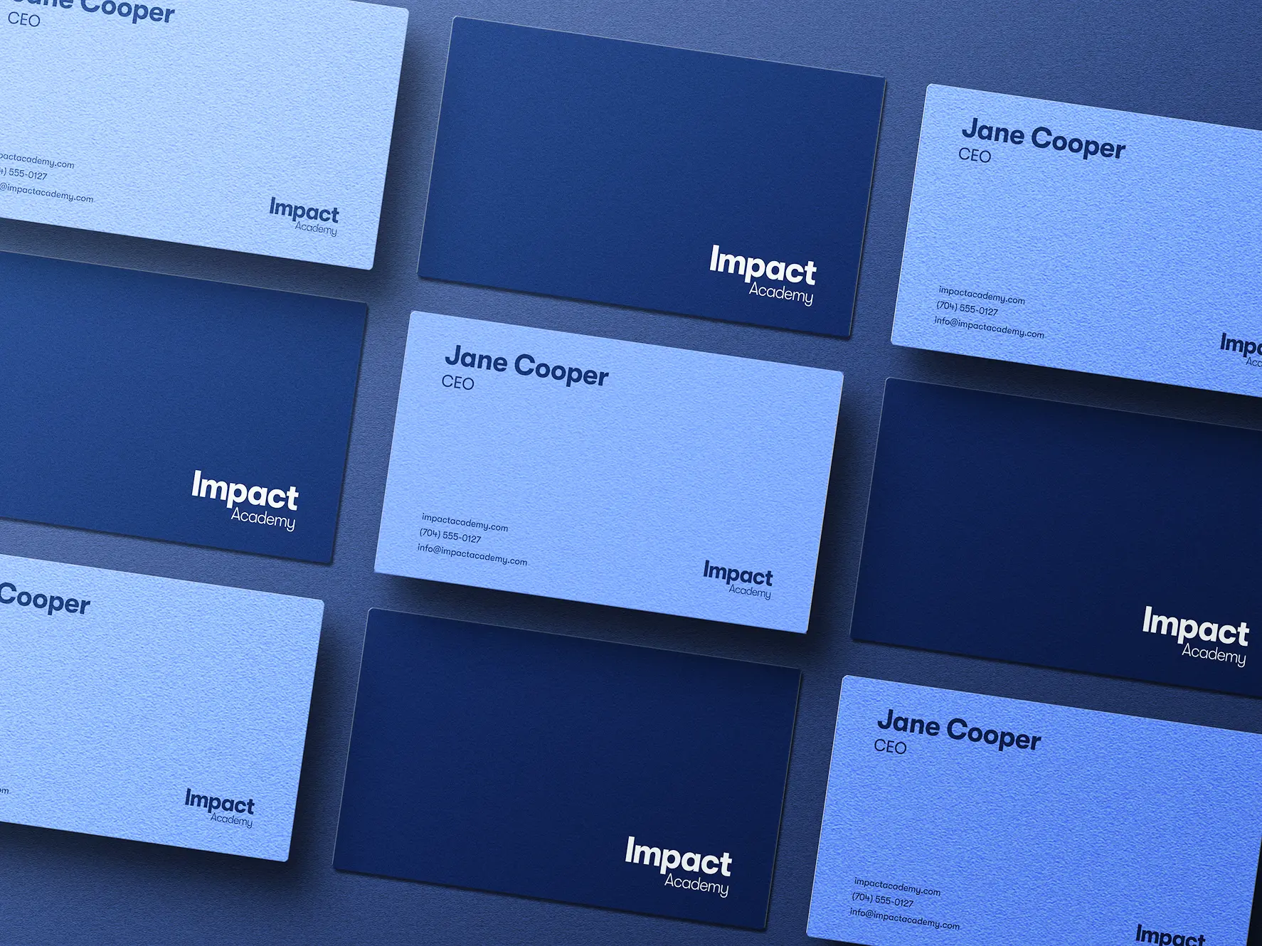 Impact Academy business cards arranged in a grid across navy and light blue stock.