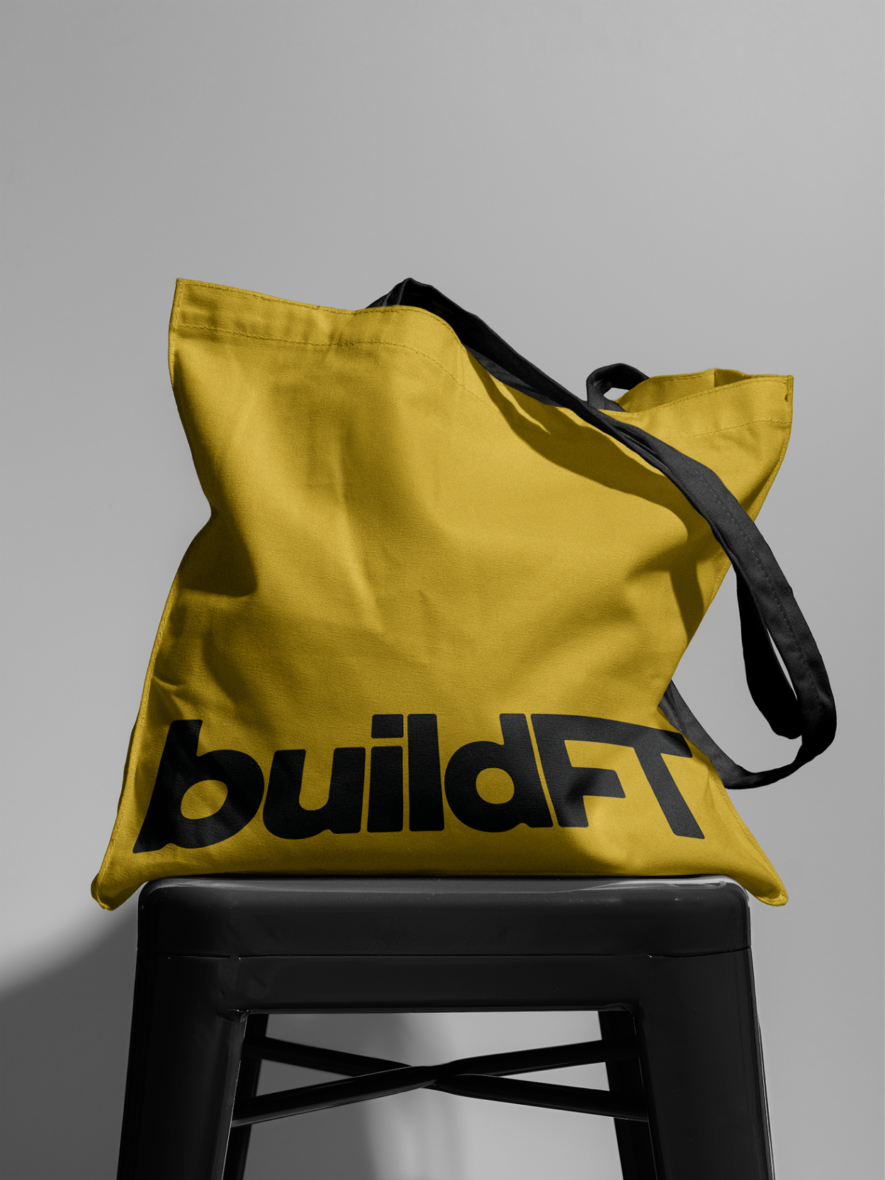BuildFT branded tote bag displayed on a stool.