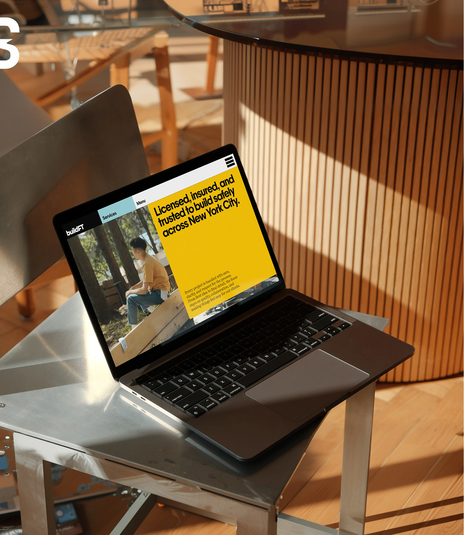 BuildFT website mockup displayed on a laptop in a warm interior setting.