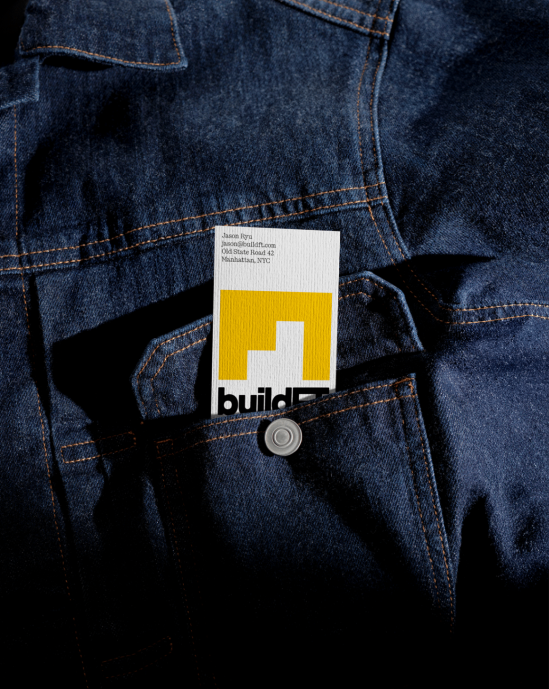 BuildFT business card tucked into a dark denim jacket pocket.