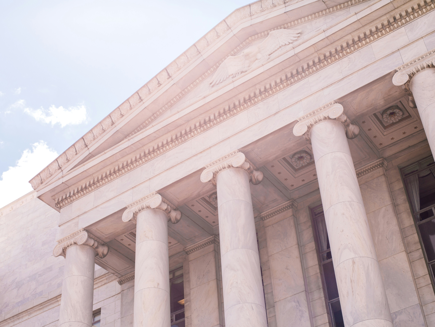 Neoclassical government building facade with grand columns, symbolizing the need for human-centered design in public institutions. The elegant architecture contrasts with modern expectations for accessible and user-friendly government services.